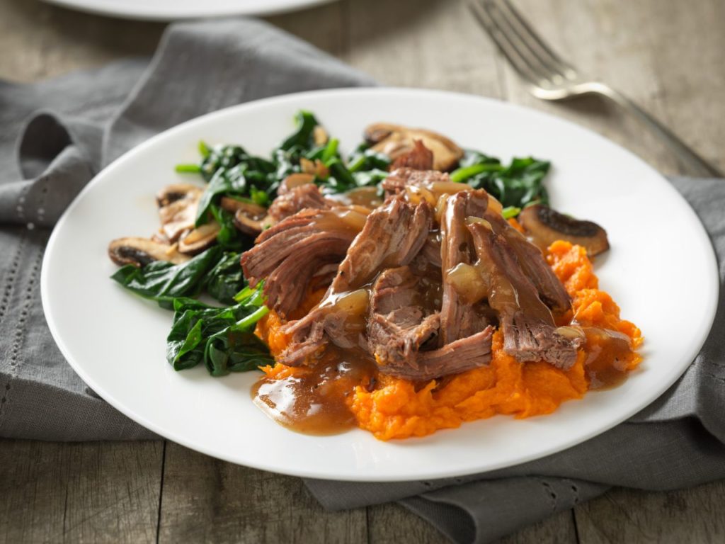 a plated serving of pot roast with maple sweet potatoes and cider gravy