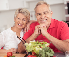 older couple smiling with salad