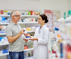 pharmacist woman helping man with pill bottle