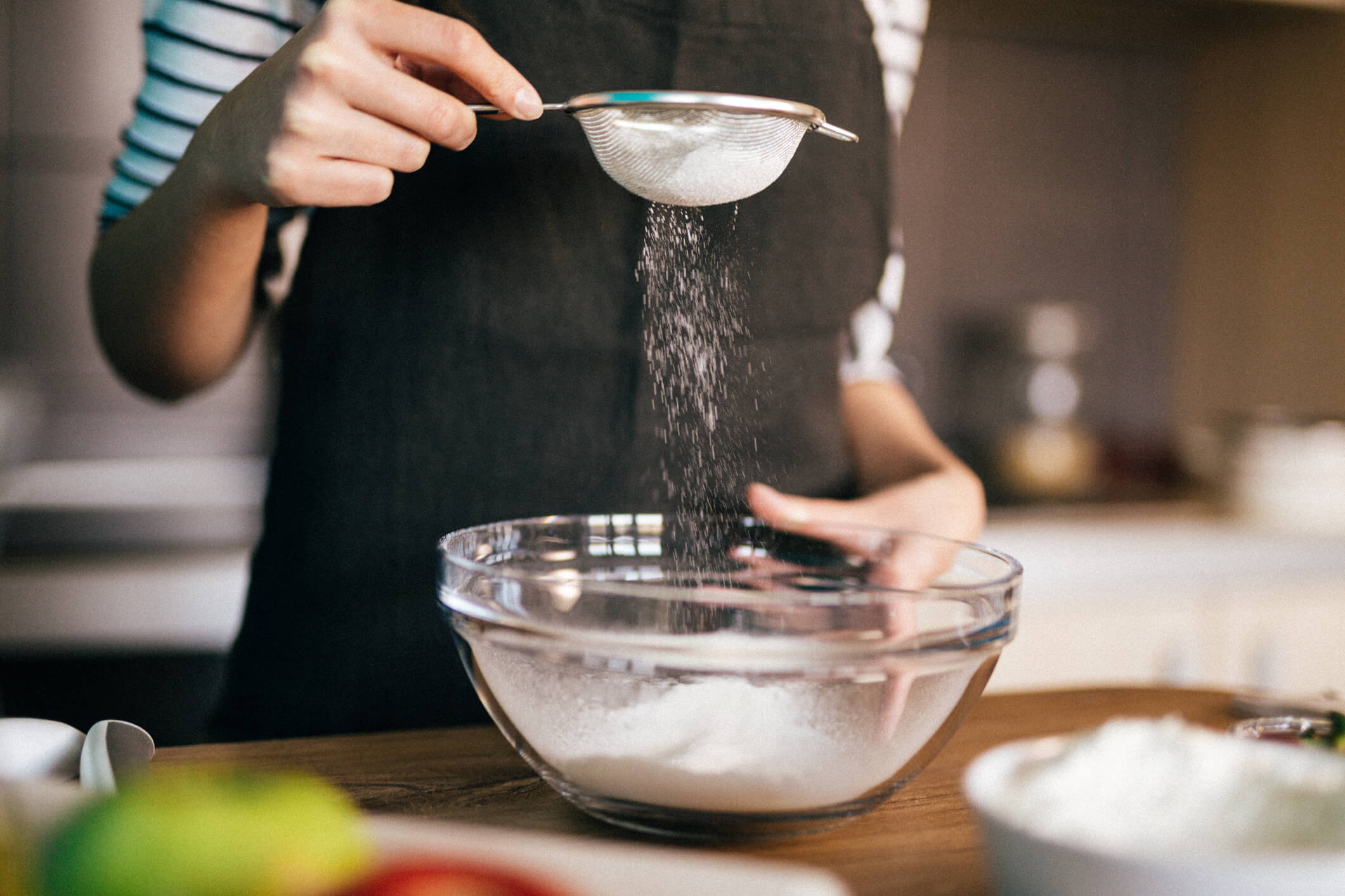 Sifting dry ingredients into a bowl while baking