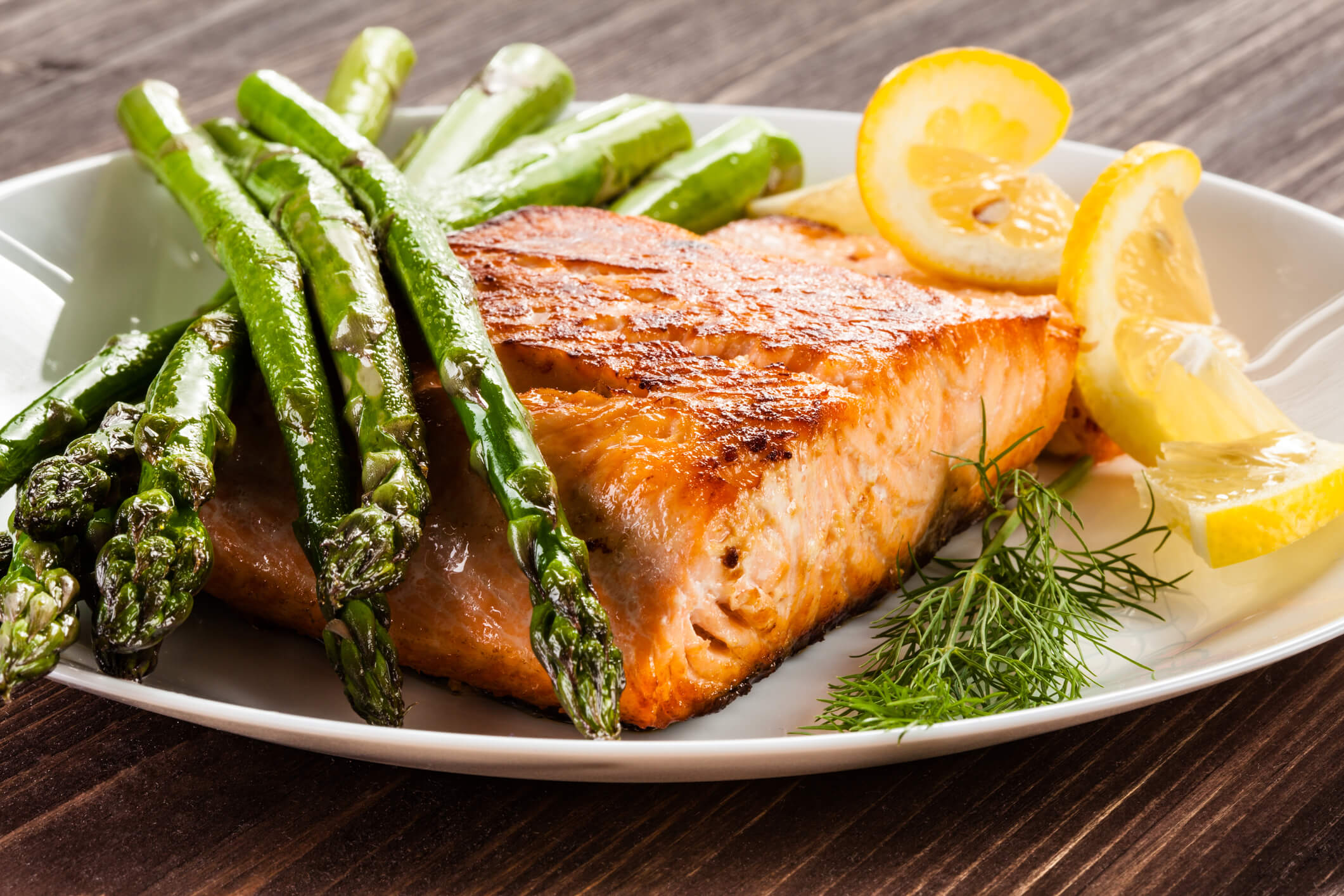 A plate of heart-healthy salmon with asparagus and lemon.