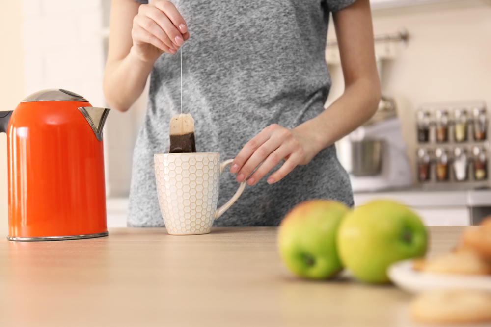 A woman steeps her tea carefully to get the perfect tea-to-water ratio.