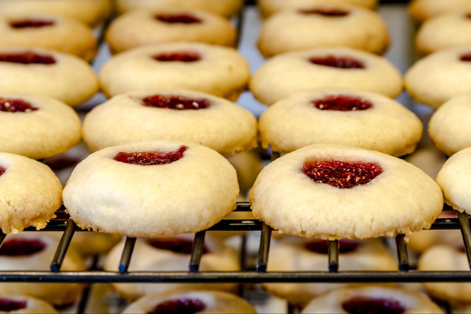 Raspberry thumbprint cookies cooling on a tray