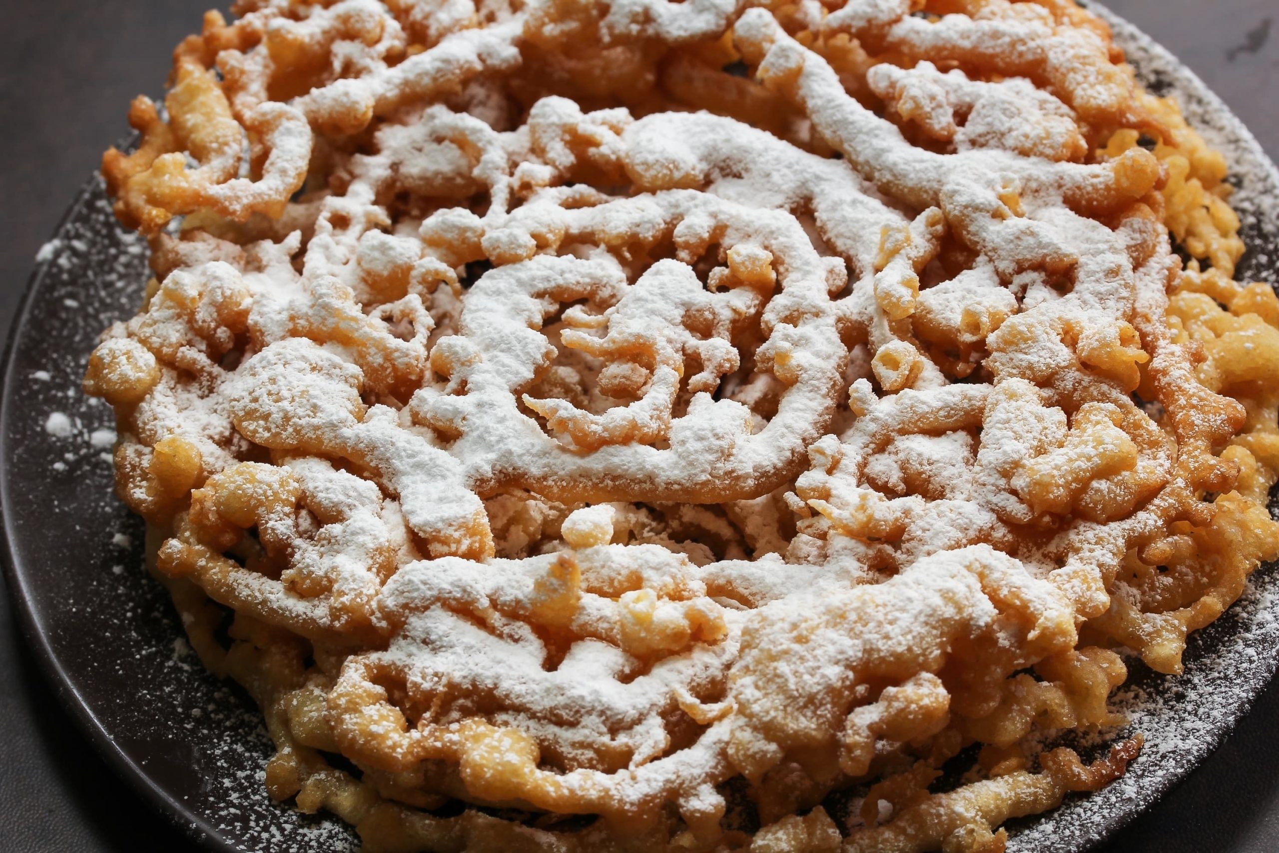 Traditional Amish funnel cake with powdered sugar.