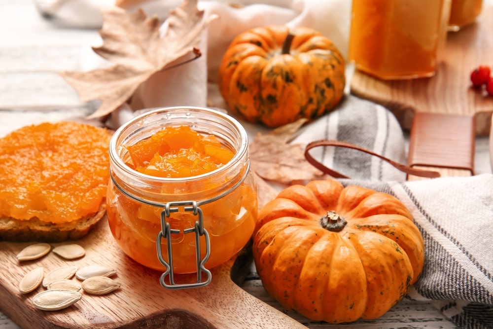 Small pumpkins and a jar of pumpkin jam on a table
