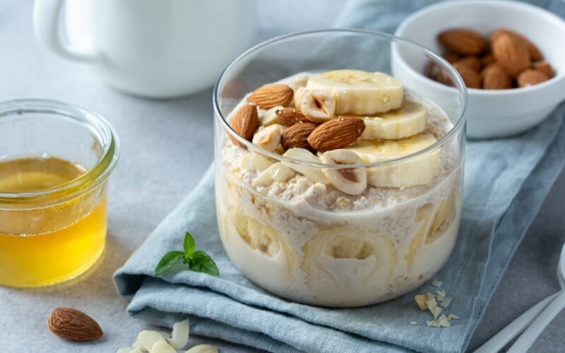A bowl of overnight oats on a cloth napkin garnished with almonds.