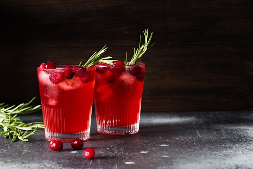 2 cranberry mocktails in glasses with cranberry garnish.