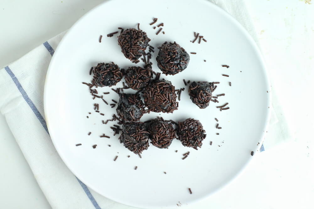 Oreo balls, an easy Thanksgiving dessert, covered in chocolate sprinkles on a white plate