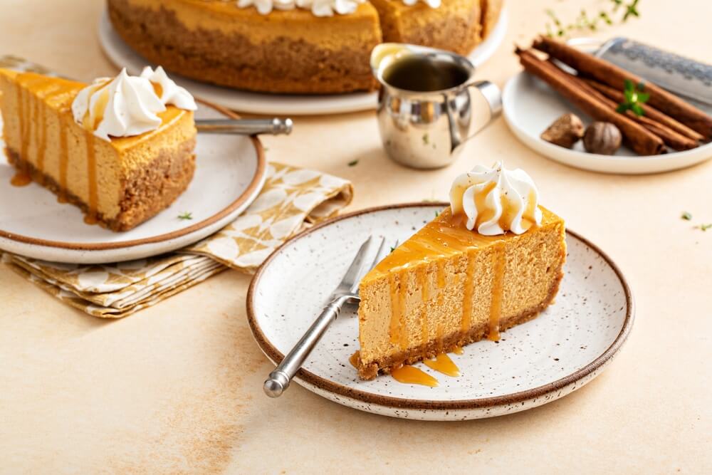 A slice of easy Thanksgiving no bake pumpkin cheesecake on a white plate
