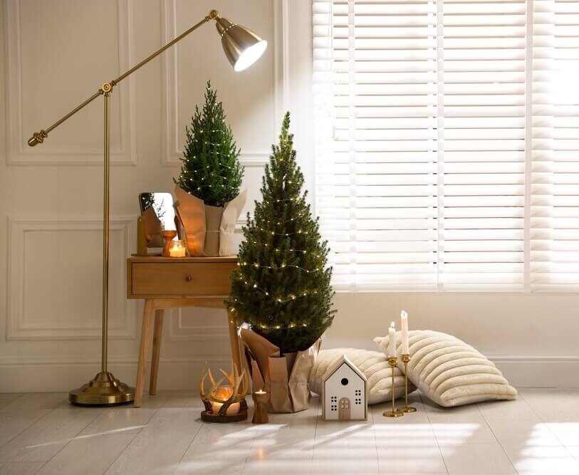 Small Christmas trees and other holiday decor in the corner of a room