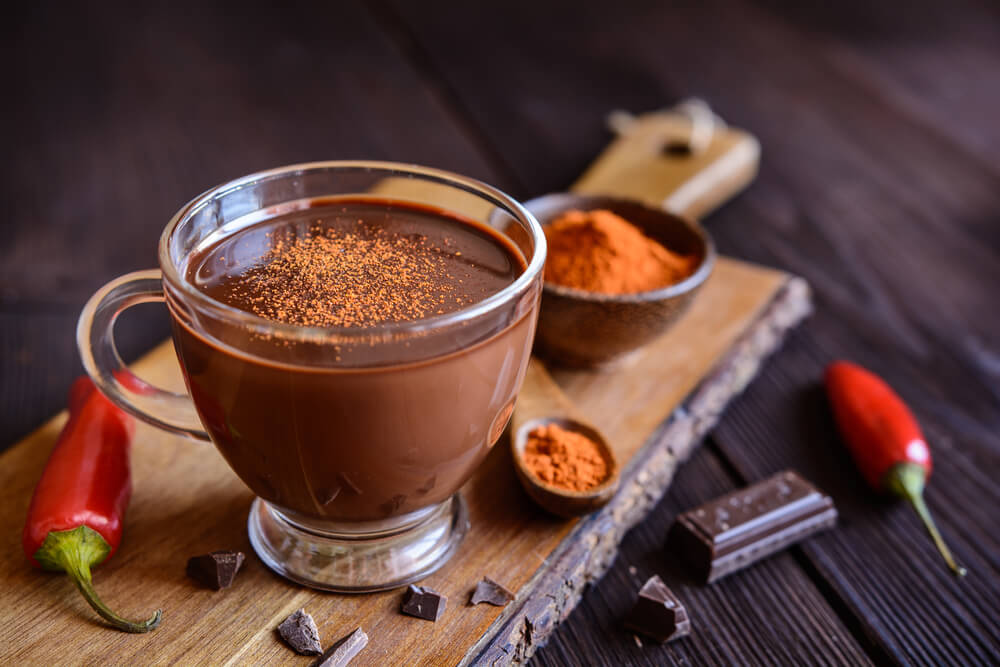 A cup of spiced hot chocolate with chili powder on top