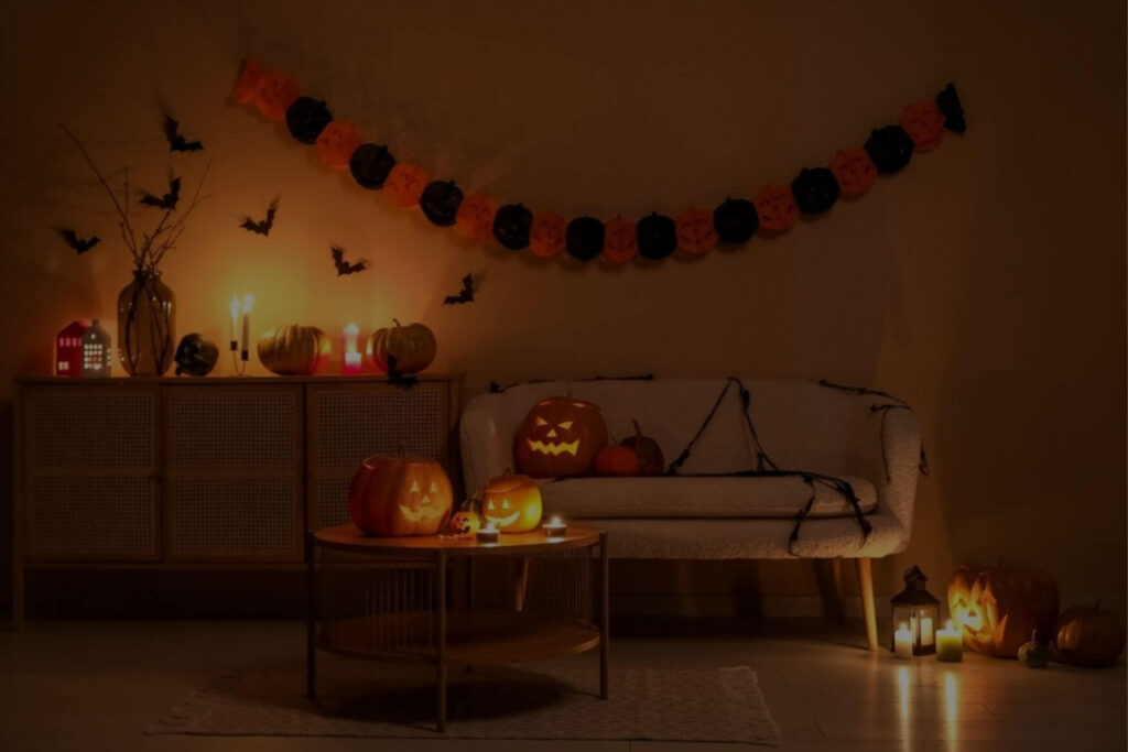 Living room showing Halloween decor, including light-up pumpkins and bats on the wall